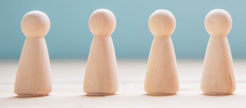 Eine Reihe von Spielfiguren aus Holz (Foto: Alexa – Pixabay)